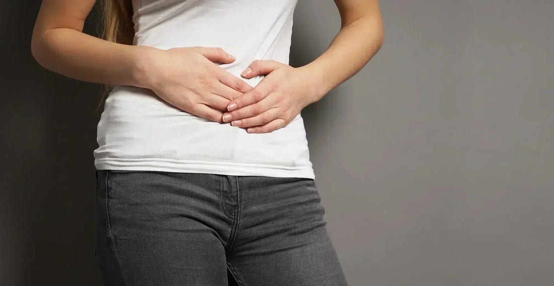 Une jeune femme souffrant de maux de ventre et se demandant que manger dans le cas de l'intestin irritable