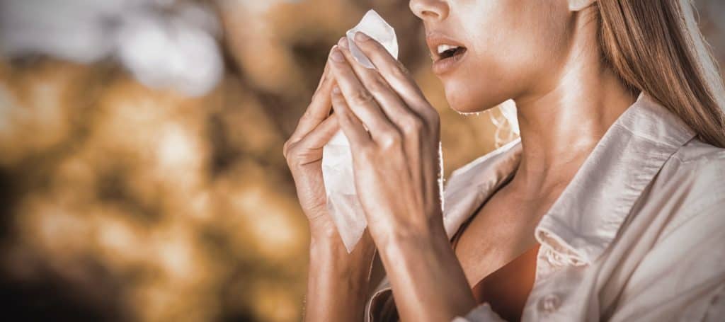 Cette femme qui éternue dans son muchoir semble avoir des défenses naturelles faibles