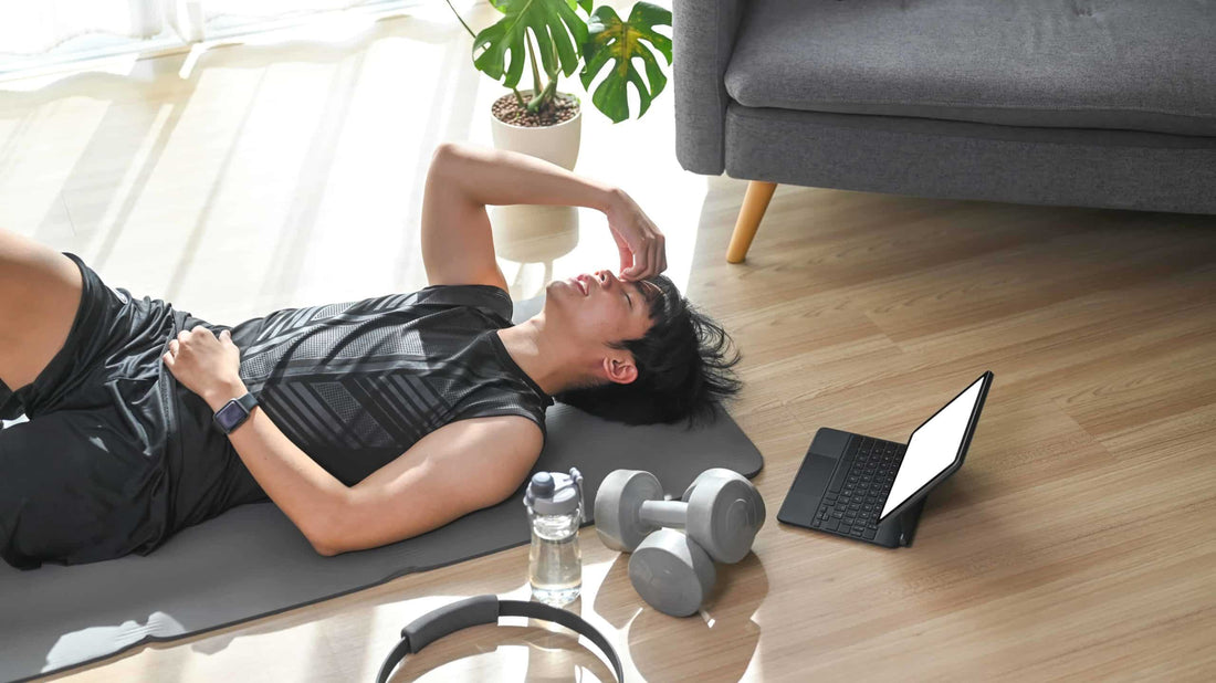 homme fatigué allongé sur le sol à coté d'accessoires de sport