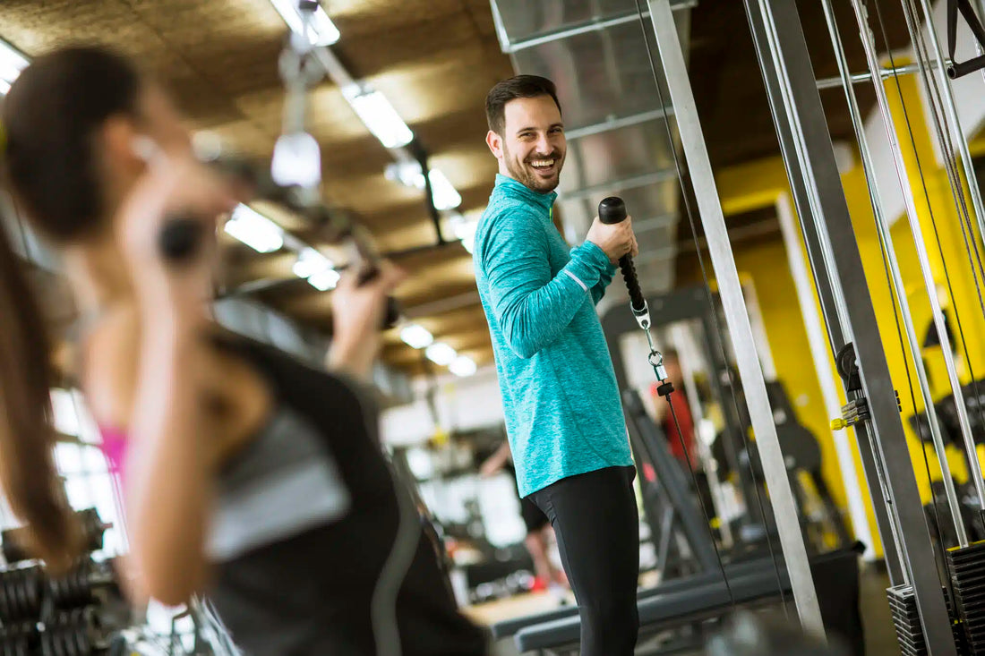 omega 3 musculation Jeune couple exerce des exercices de musculation dans une salle de sport moderne