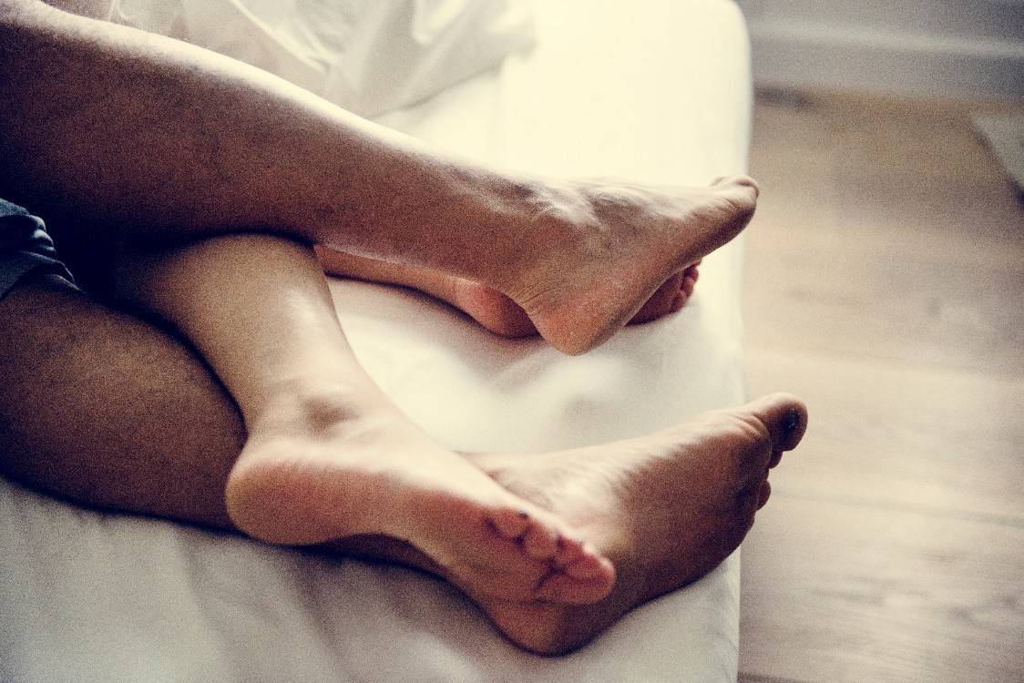 jambes d’un couple dormant paisiblement dans leur lit